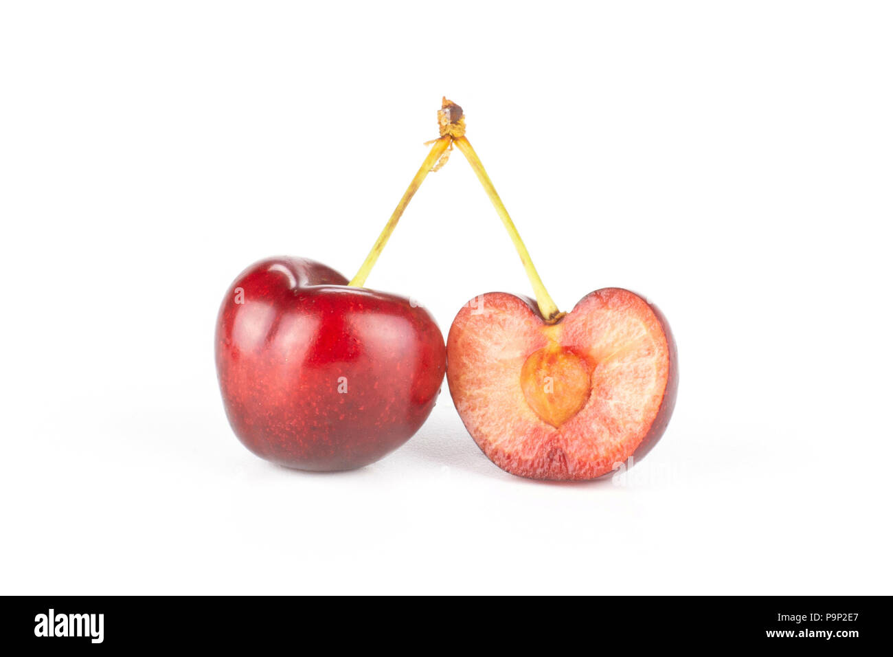 Gruppe von einer ganzen Hälfte der süßen helle rote Kirsche isoliert auf weißem Stockfoto