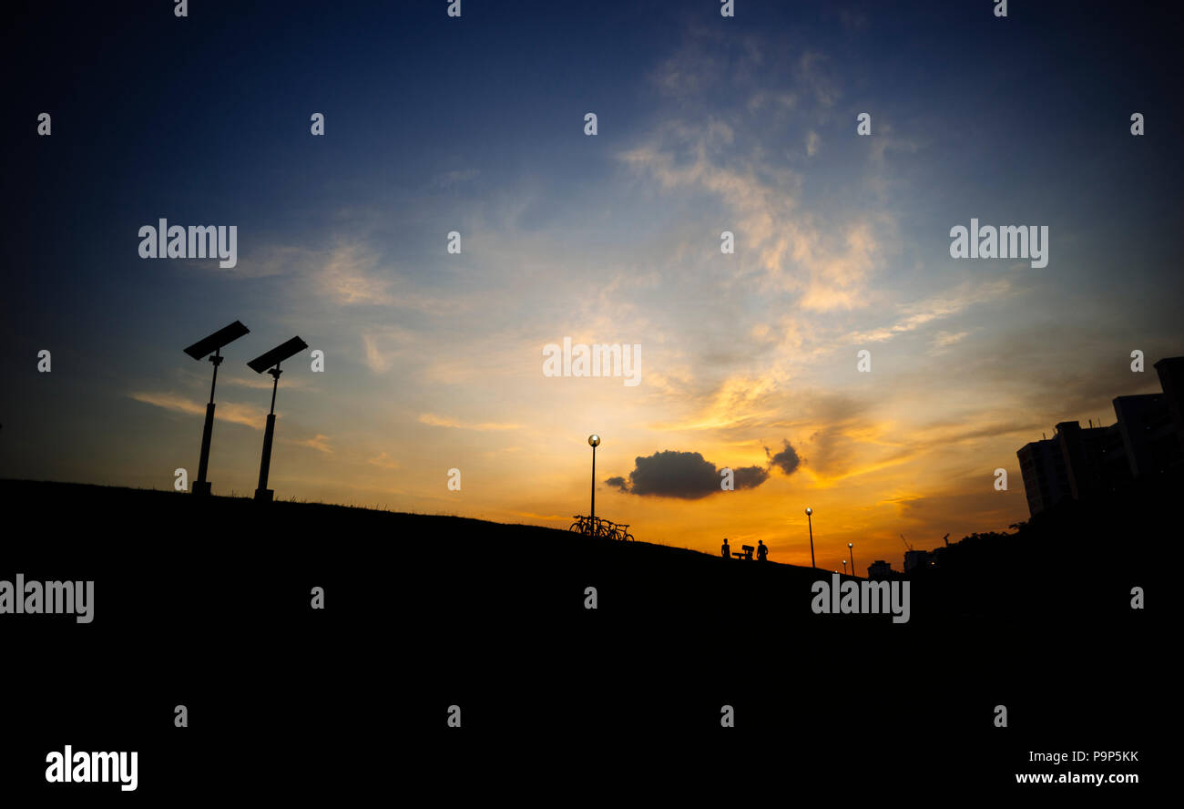 Szene mit frühen Sonnenuntergang mit Menschen für einen Spaziergang in der Ferne Stockfoto