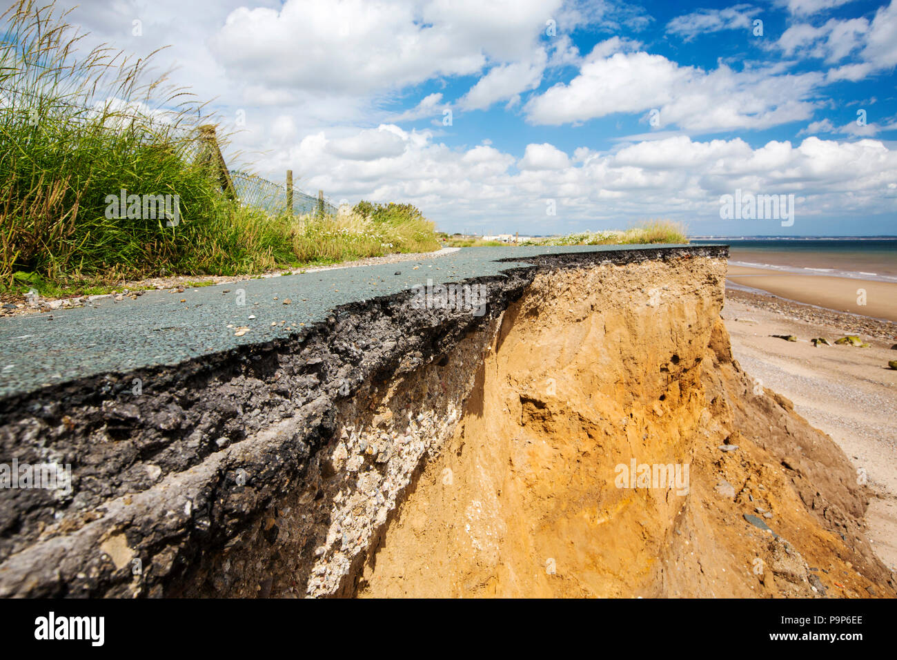 Eine kollabierte Küstenstraße zwischen Skipsea und Ulrome auf Yorkshires Ostküste, in der Nähe von Skipsea, Großbritannien. Die Küste besteht aus weichem Boulder Tone, sehr anfällig für die Erosion der Küsten. Dieser Abschnitt der Küste ist schon erodiert seit der Römerzeit, mit vielen Dörfern, die sich in der Meer verschwunden, und ist der schnellste erodieren Küste in Europa. Der Klimawandel ist die Beschleunigung der Erosion, mit Anstieg des Meeresspiegels, erhöhte stürmisches Wetter und mehr Starkregen, alle ihren Teil zu spielen. Stockfoto