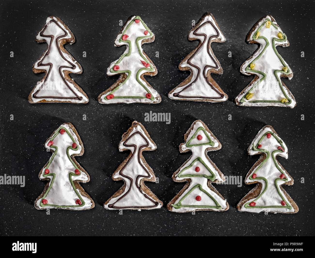Christmas Tree-förmige Lebkuchen cookies mit weißer Zuckerglasur Schuß von oben über Schwarz Stockfoto