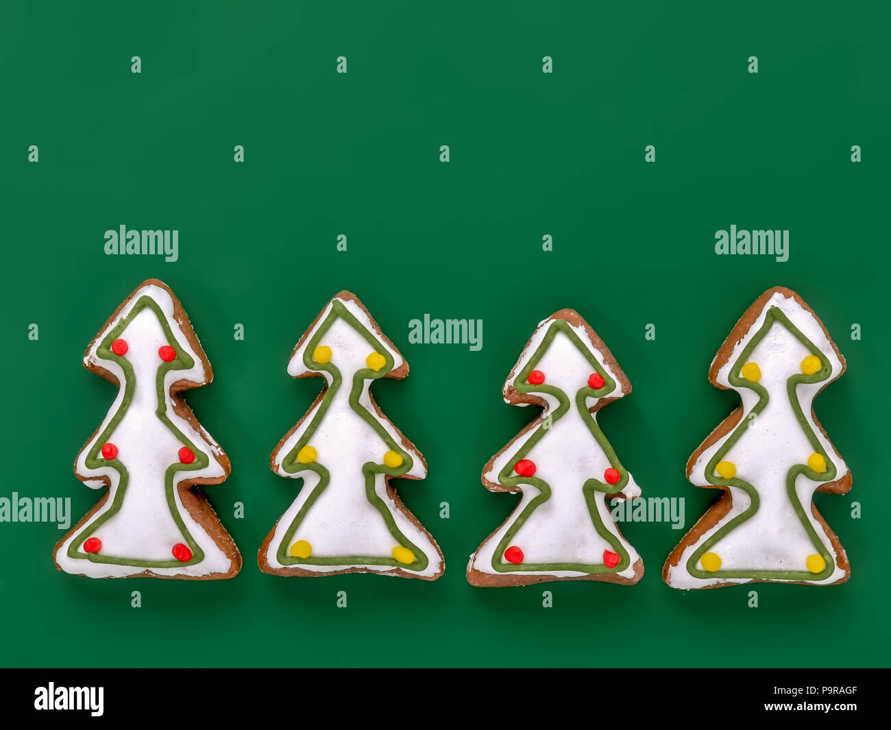 Christmas Tree-förmige Lebkuchen cookies mit weißer Zuckerglasur Schuß von oben über grüner Hintergrund Stockfoto