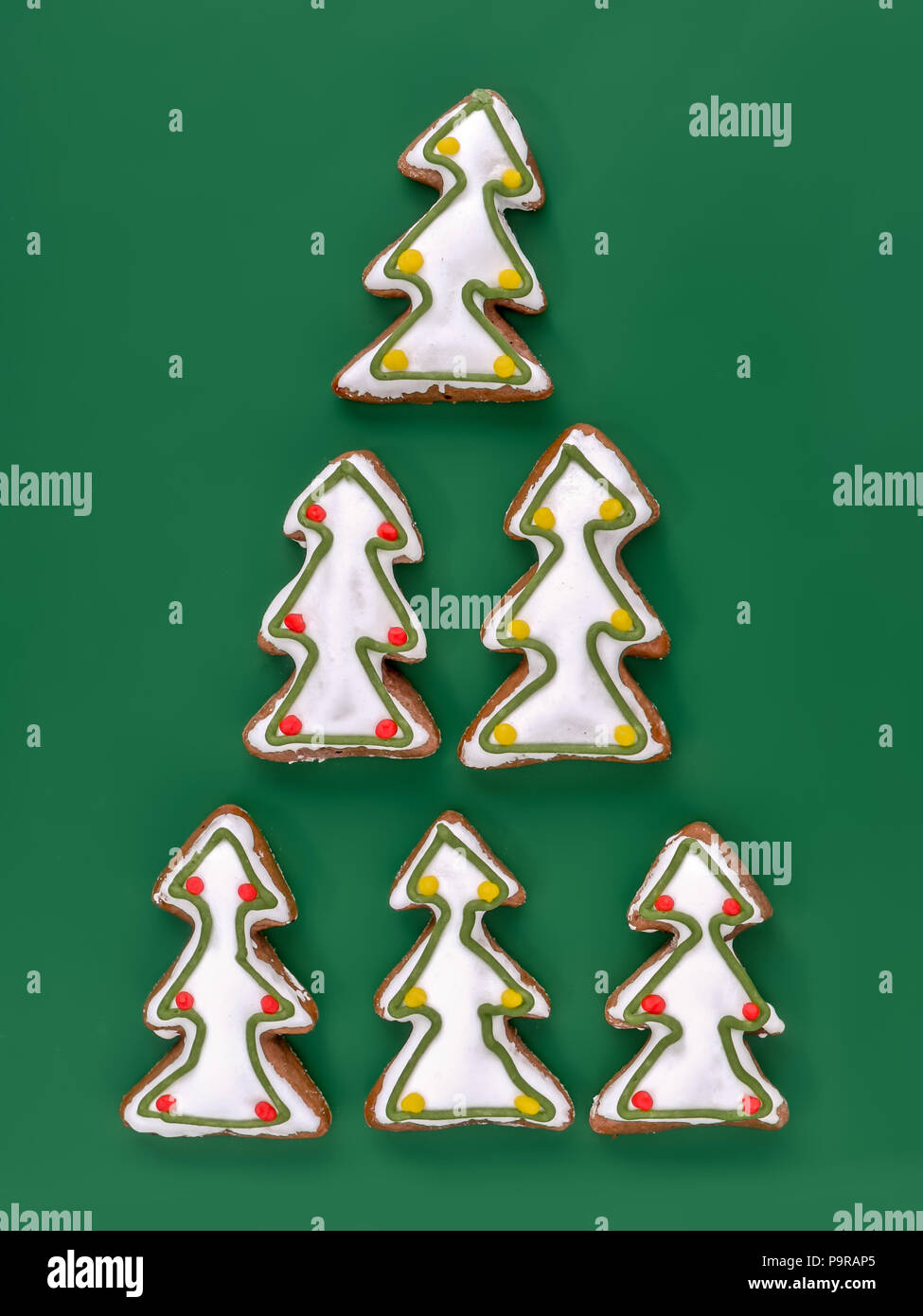 Christmas Tree-förmige Lebkuchen cookies mit weißer Zuckerglasur Schuß von oben über grüner Hintergrund Stockfoto