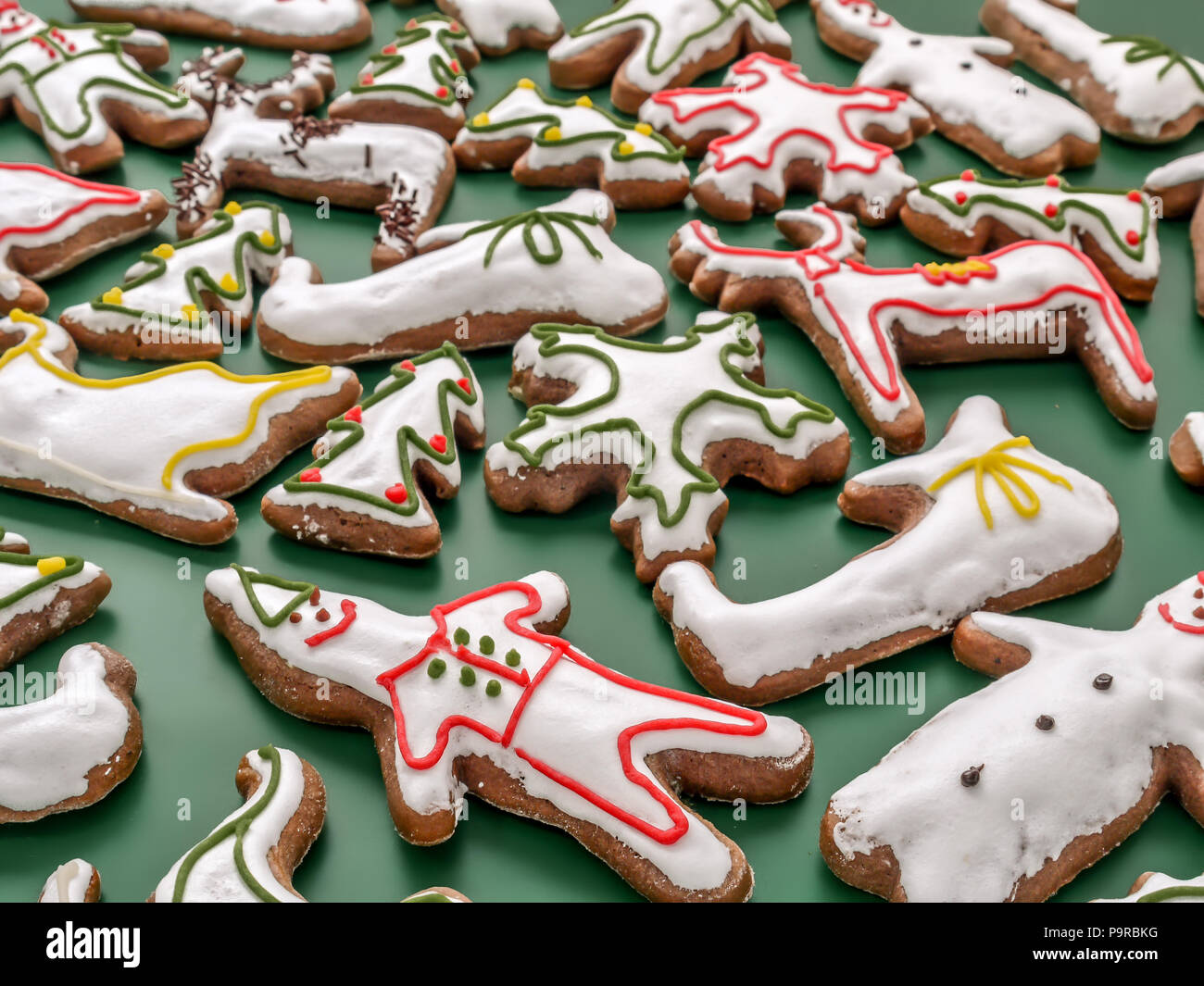 Saisonal geprägt Lebkuchen cookies mit weißer Zuckerglasur auf grünem Hintergrund Stockfoto