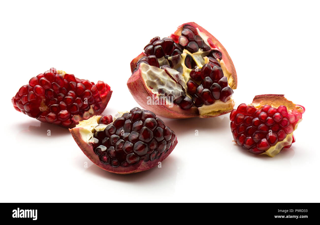 Vier Granatapfel Stücke mit Körnern auf weißem Hintergrund Stockfoto