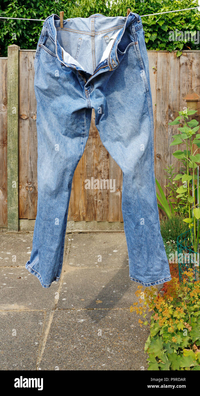 Ein paar blaue Jeans hängen an einer Wäscheleine zum Trocknen. Stockfoto