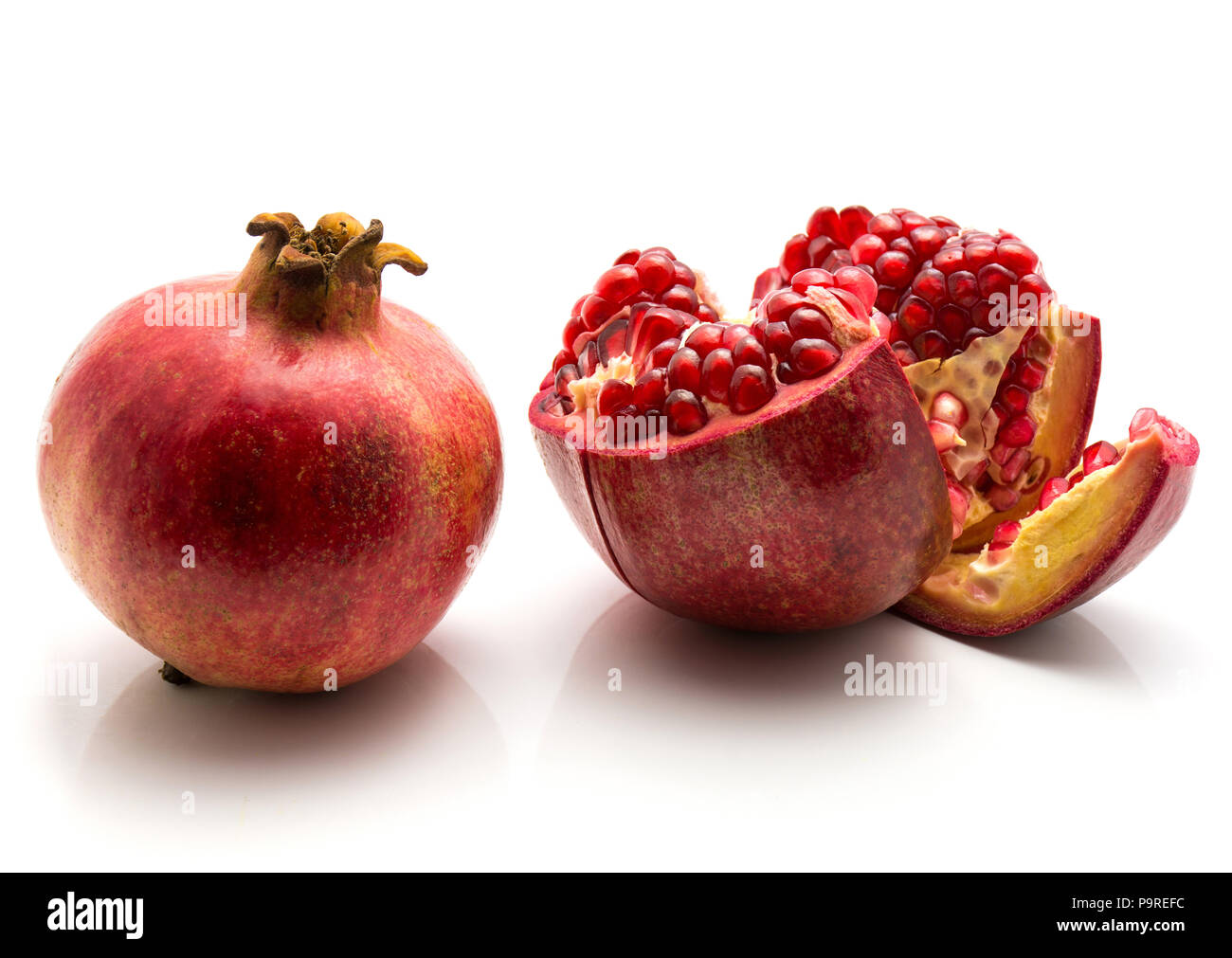 Zwei Granatapfel auf weißem Hintergrund eine ganze und eine offene isoliert Stockfoto