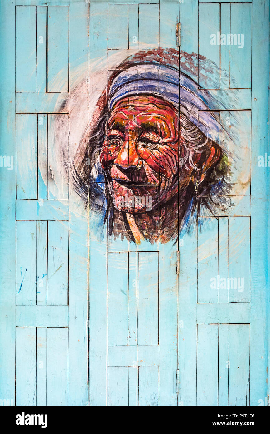 Street Art Graffiti eines älteren Gesicht malen auf einem bunten Holztür, Bhaktapur, Nepal Stockfoto