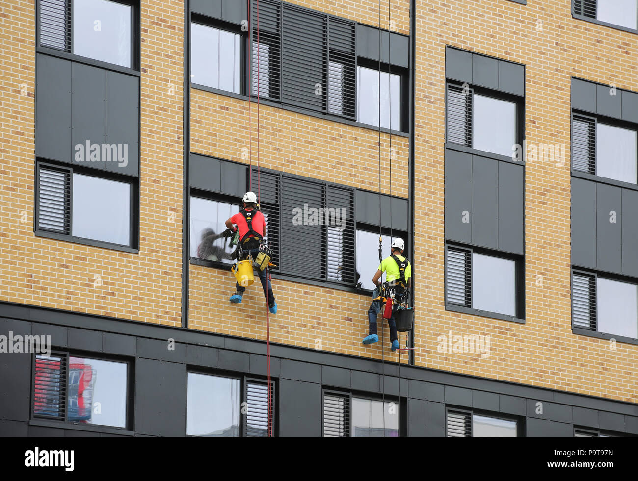 Zwei Fenster Reinigungsmittel verwenden abseilen Seile Windows auf ein neues Bürogebäude im Zentrum von Portsmouth, Hampshire, UK zugreifen Stockfoto