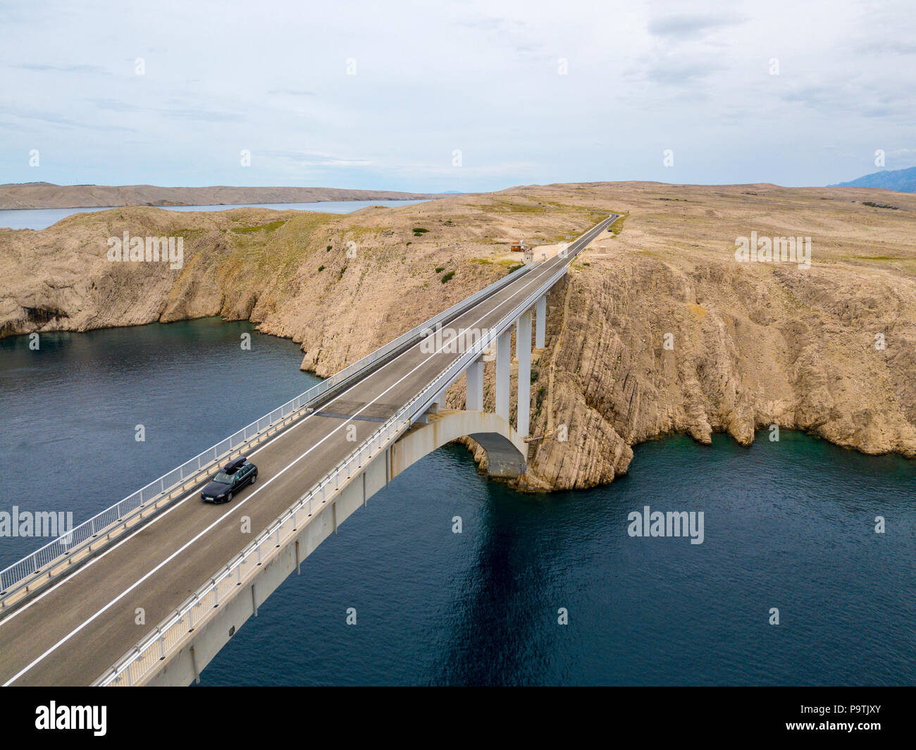 Luftaufnahme der Brücke von der Insel Pag, Kroatien, Straße. Klippe mit Blick auf das Meer. Autos über die Brücke von oben gesehen Stockfoto