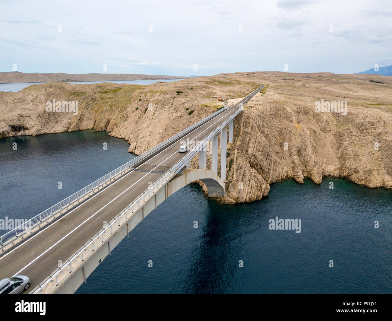 Luftaufnahme der Brücke von der Insel Pag, Kroatien, Straße. Klippe mit Blick auf das Meer. Autos über die Brücke von oben gesehen Stockfoto