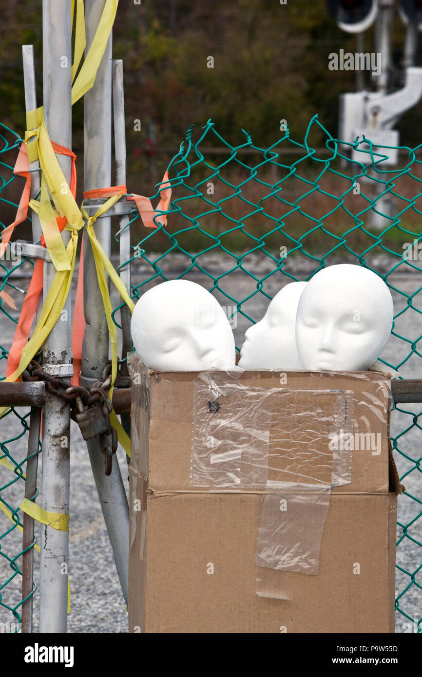 Styropor Mannequin heads sitzen in einem Karton in einem verlassenen Parkplatz Stockfoto