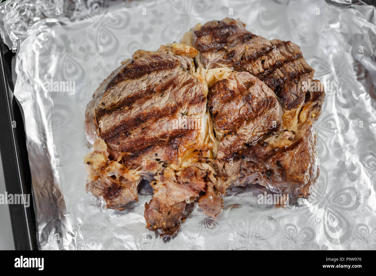 Close-up Lecker saftiges Rib Eye Steak auf Aluminium- Folie. . Bio  Rindfleisch gewürzt mit Pfeffer coocked im Ofen nach dem Grill  Stockfotografie - Alamy