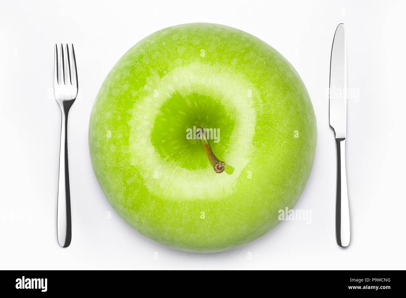 Diät Konzept, grüner Apfel auf einem weissen Teller, Gabel, Messer, Gewicht Stockfoto