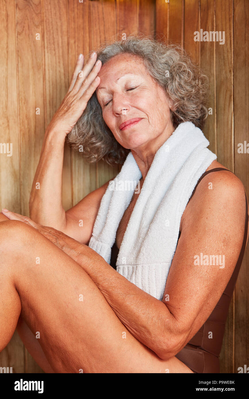Senior genießt ihren Ruhestand und schwitzt in der Sauna Stockfoto