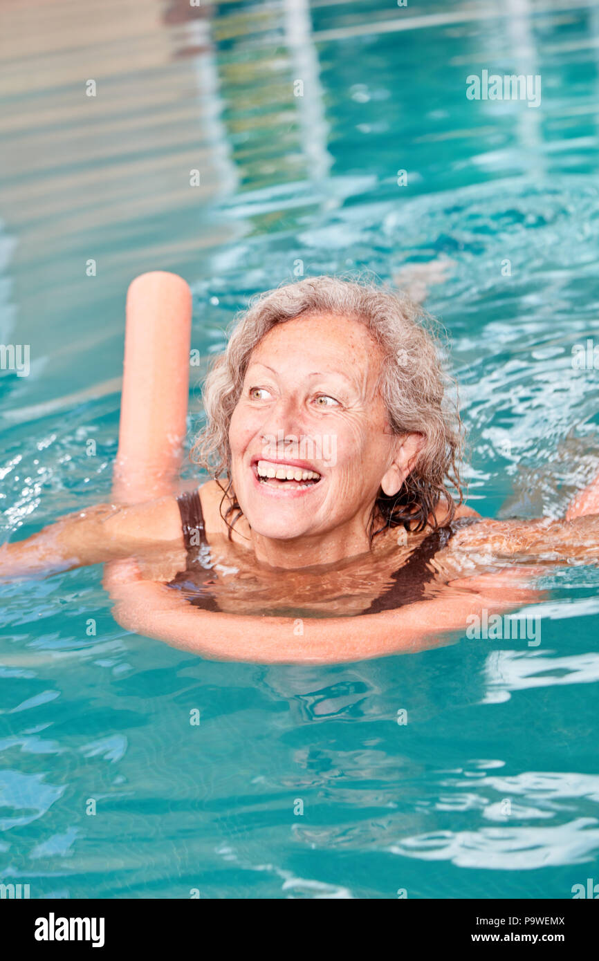 Vitale ältere Frau ist Schwimmen lernen schwimmen Nudel im Pool Stockfoto
