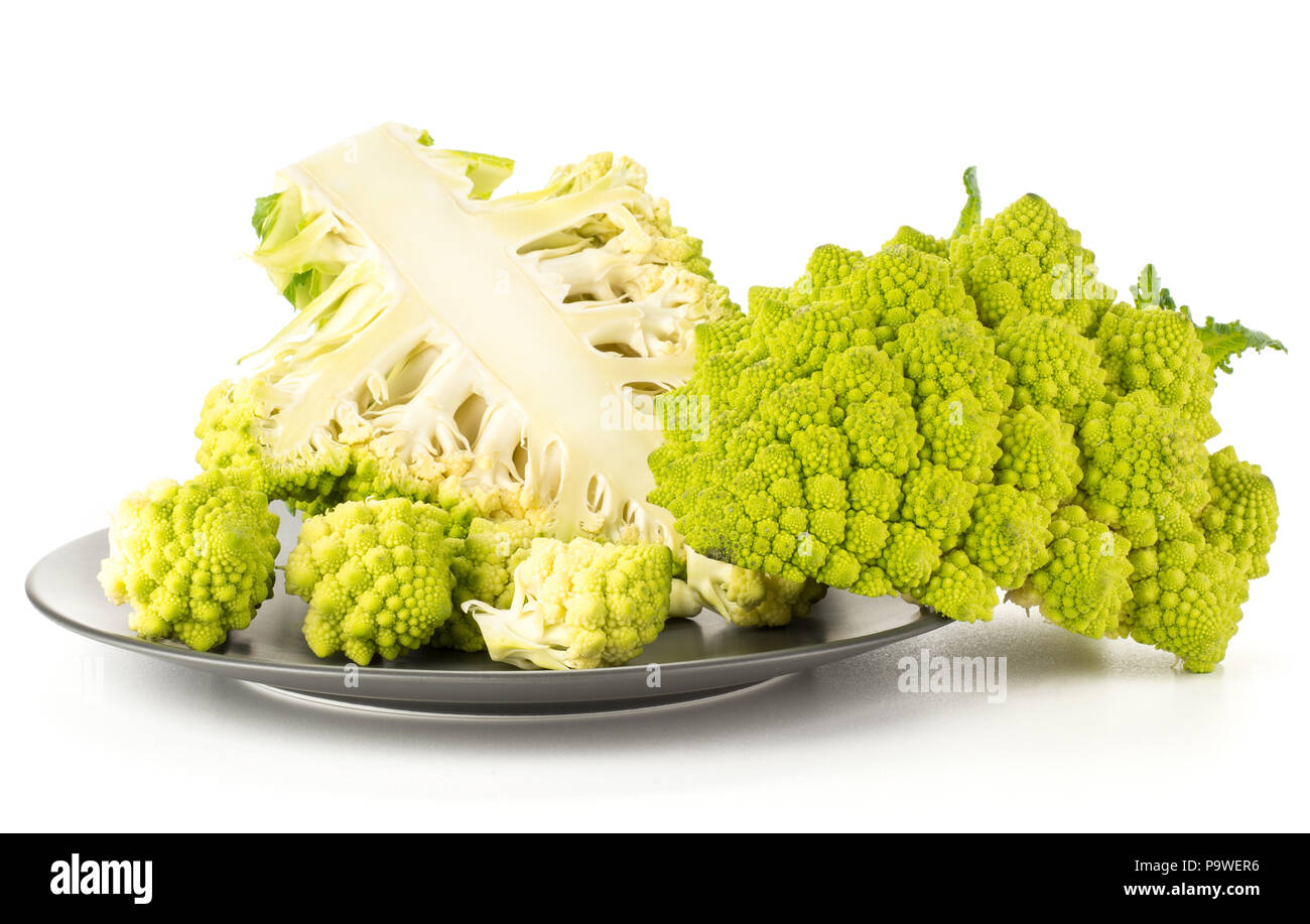Grün Romanesco Blumenkohl auf einem grauen Platte auf weißem Hintergrund zwei Hälften geschnitten und mehrere Stücke isolierte Gruppe Stockfoto