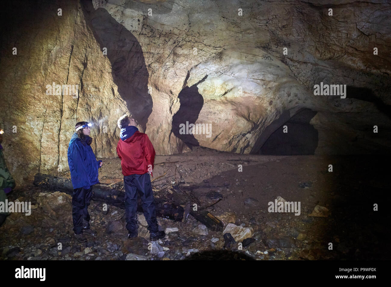 Familie der Wanderer erkunden eine Höhle in einem Kalkstein Berg Stockfoto