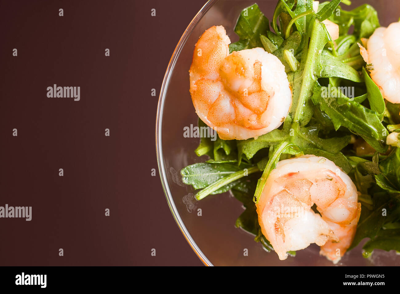 Salat aus Rucola, Garnelen, Pinienkerne, in ein Glas Kosten auf einer Ta Stockfoto