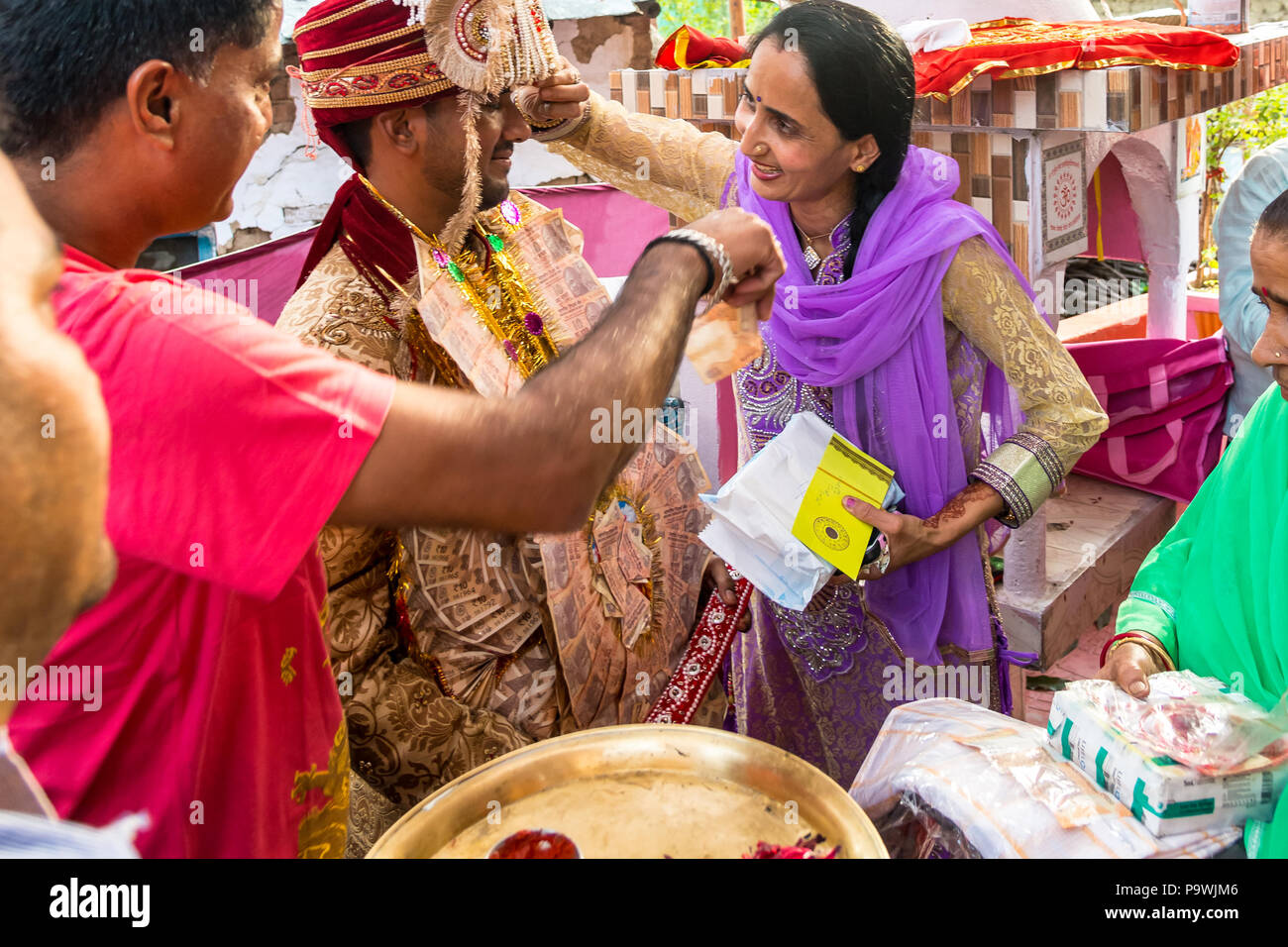 Eine traditionelle Hochzeit in der indischen Provinz.der Bräutigam akzeptiert Geschenke, Wünsche und Segnungen von seiner Familie und Gästen. Indien Juni 2018 Stockfoto