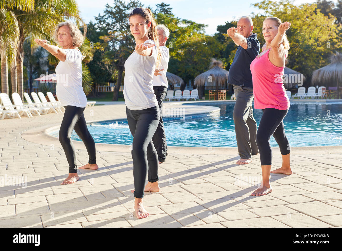 Senior Group yoga Fitness Workout am Pool im Wellness Hotel Stockfoto