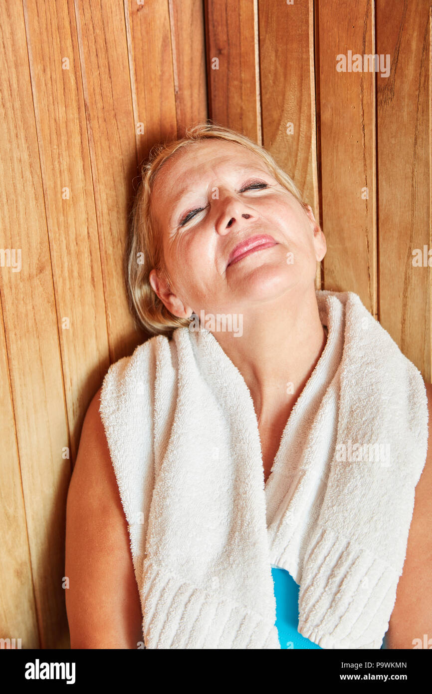 Ältere Frau genießt die gesunde Wärme in der Sauna des Wellness Hotel Stockfoto