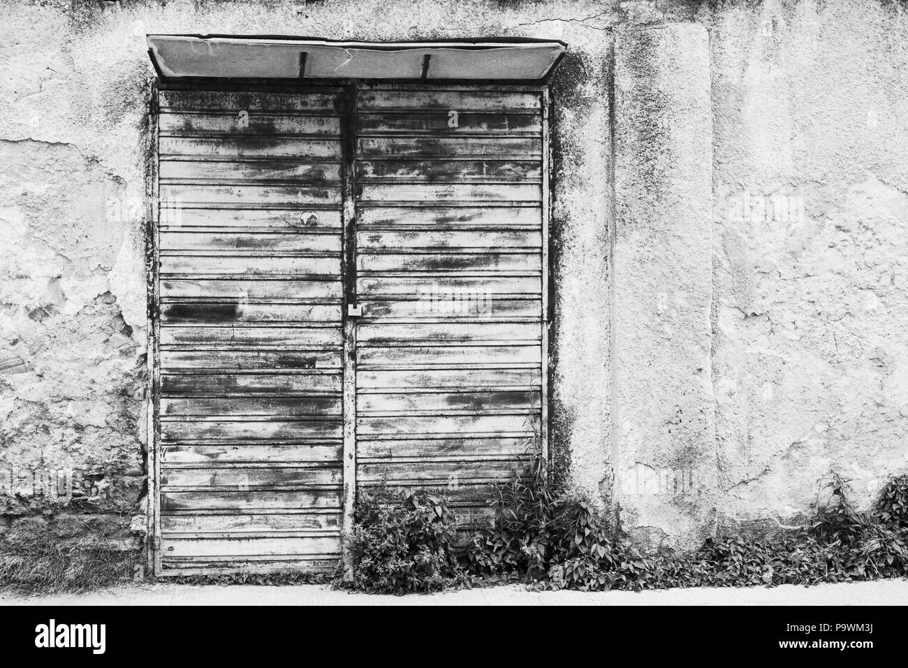 Die vordere Tür von einem verlassenen Shop. Ruinen, Decay, Einsamkeit. Schwarz und Weiß. Stockfoto