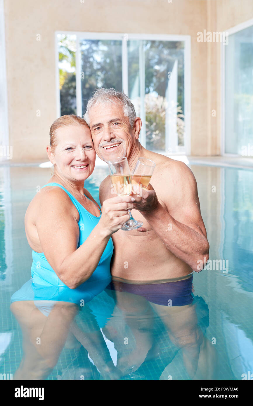 Glückliches Paar seniors im luxuriösen Spa im Pool feiert in der Liebe mit Sekt Stockfoto