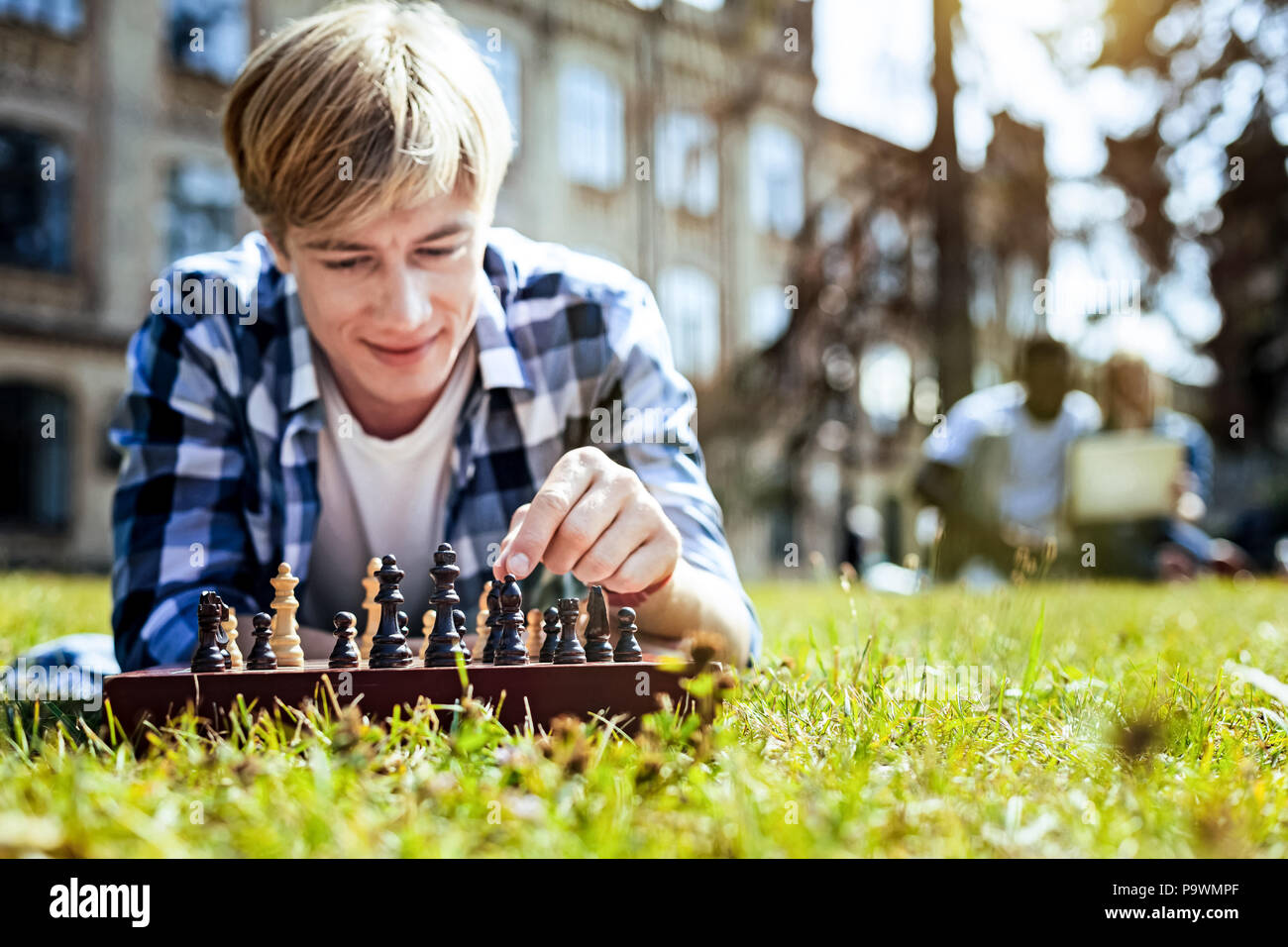 Lächelnd Kerl Spiel Schach im Freien genießen. Stockfoto