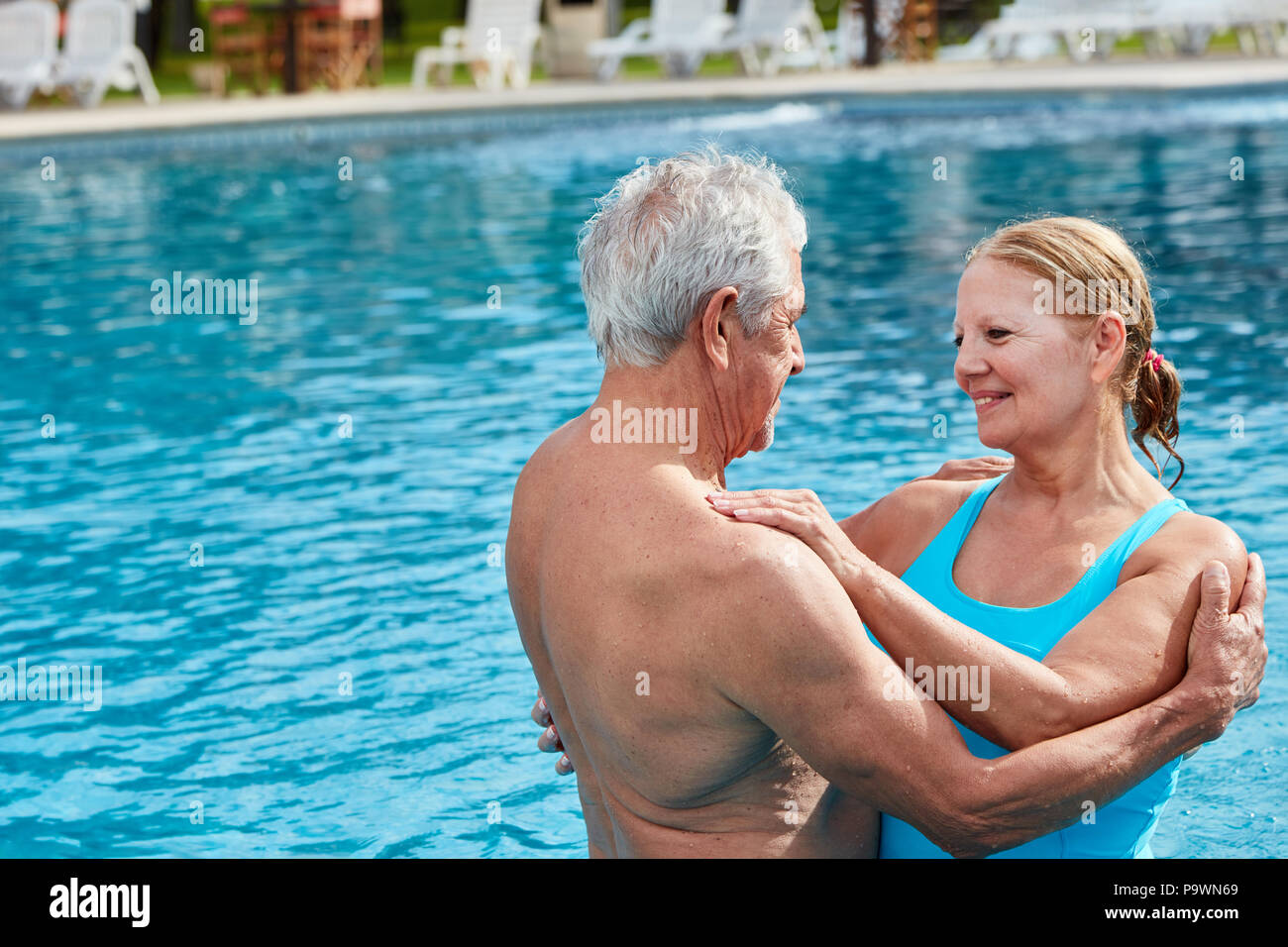 In liebe Senioren Paar im Außenpool hält zärtlich in die Arme Stockfoto