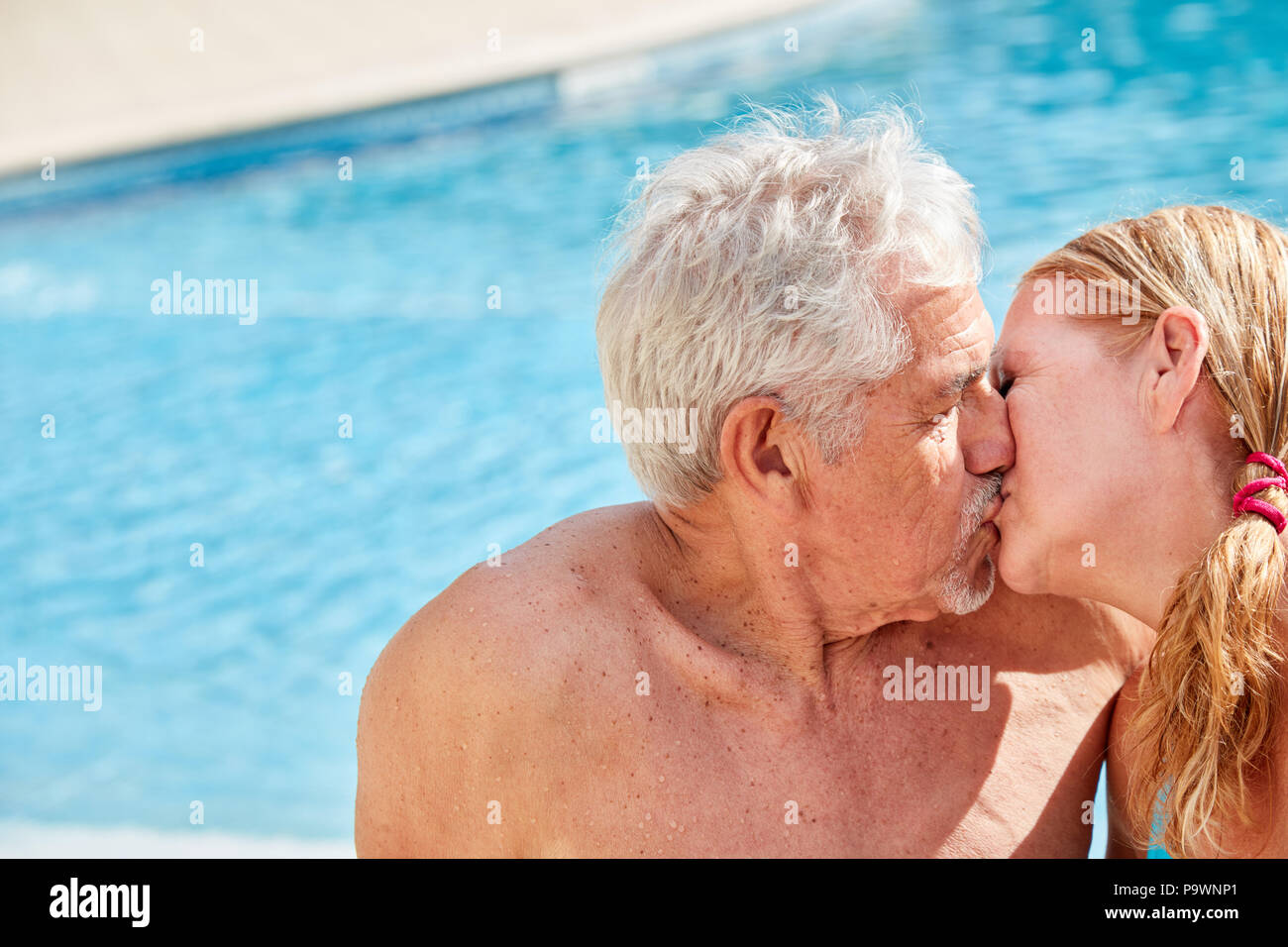 Paar in Liebe Senioren gibt einen Kuss am Pool im Sommerurlaub Stockfoto