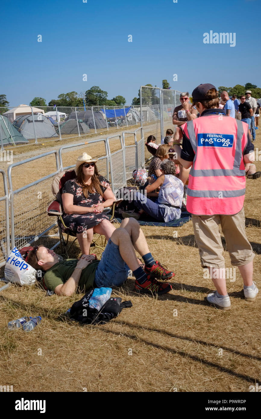 Festival Pastor plaudern für die Menschen in der Tageskarte Aufnahmen an Latitude Festival, Suffolk, Großbritannien Warteschlange. Zelte der Wochenendurlauber hinter der Barrie Stockfoto
