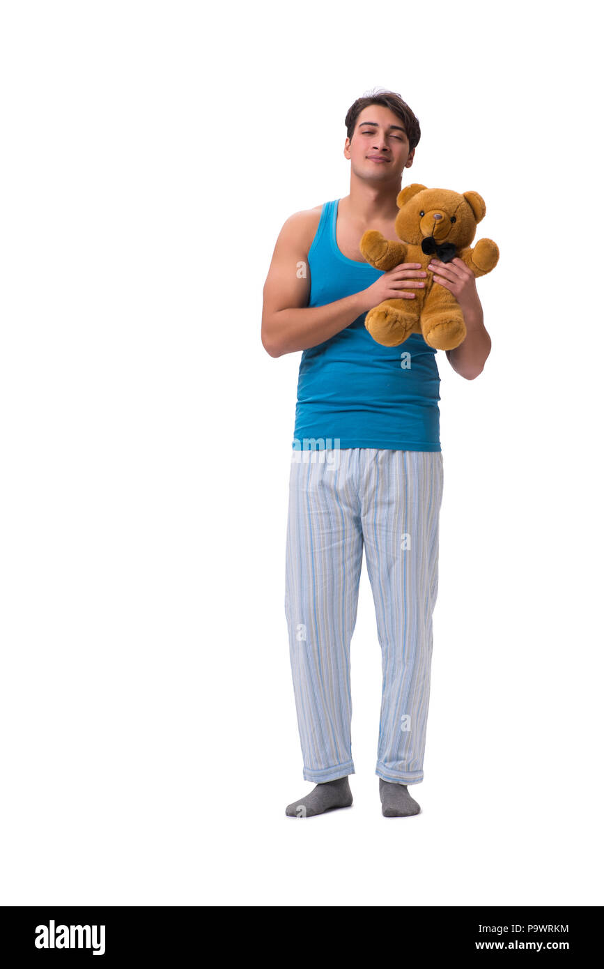 Junger Mann im Schlafanzug mit Spielzeug Tier auf weißem Hintergrund Stockfoto