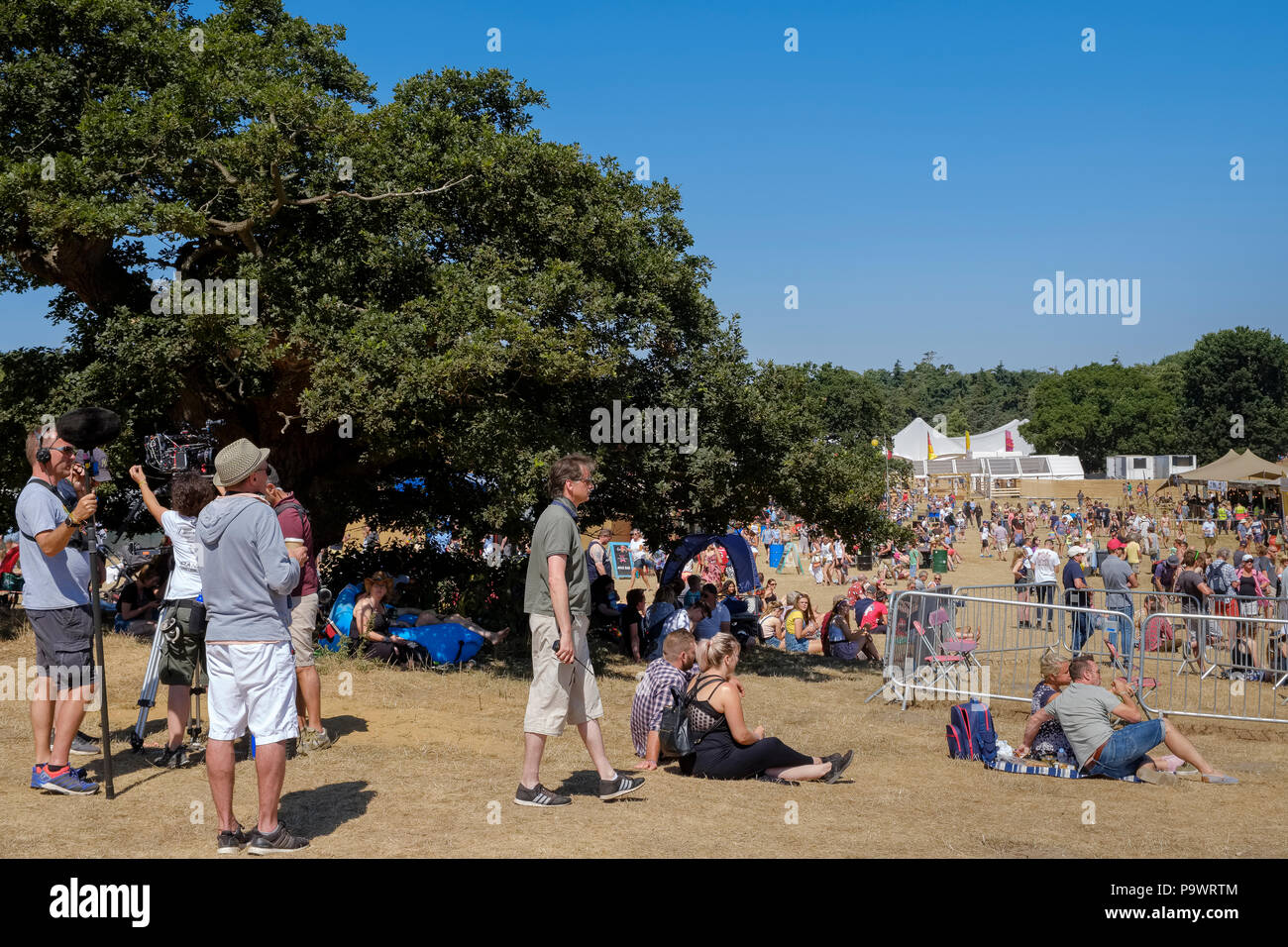 Danny Boyle und Filmteam eine Pause während der Dreharbeiten an Latitude Festival, betrachten Menschen zu Fuß rund um den Boden. Juli 2018, Suffolk, Großbritannien. Stockfoto