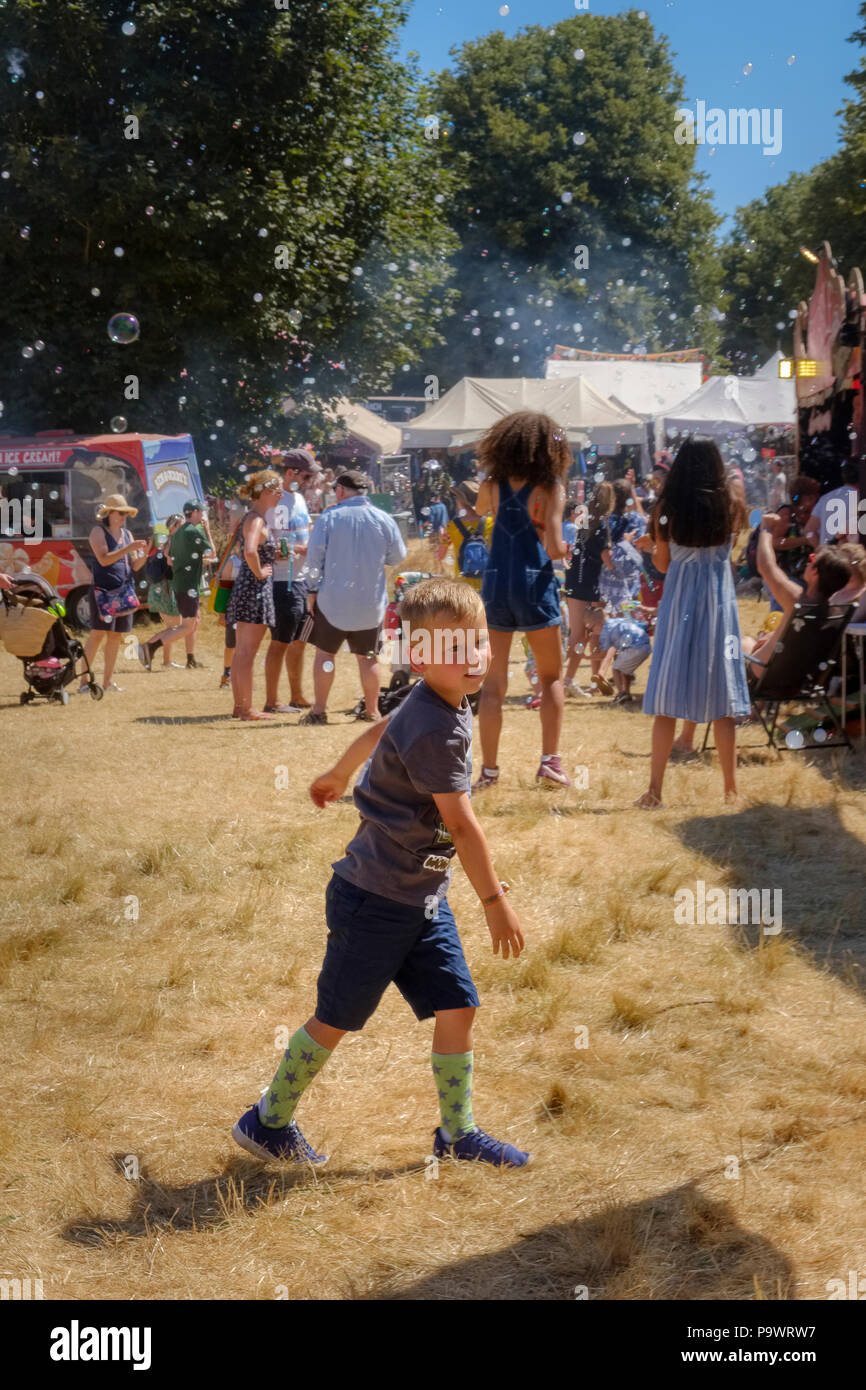 Junge jagen Blasen, Latitude Festival, Suffolk, Großbritannien. Stockfoto