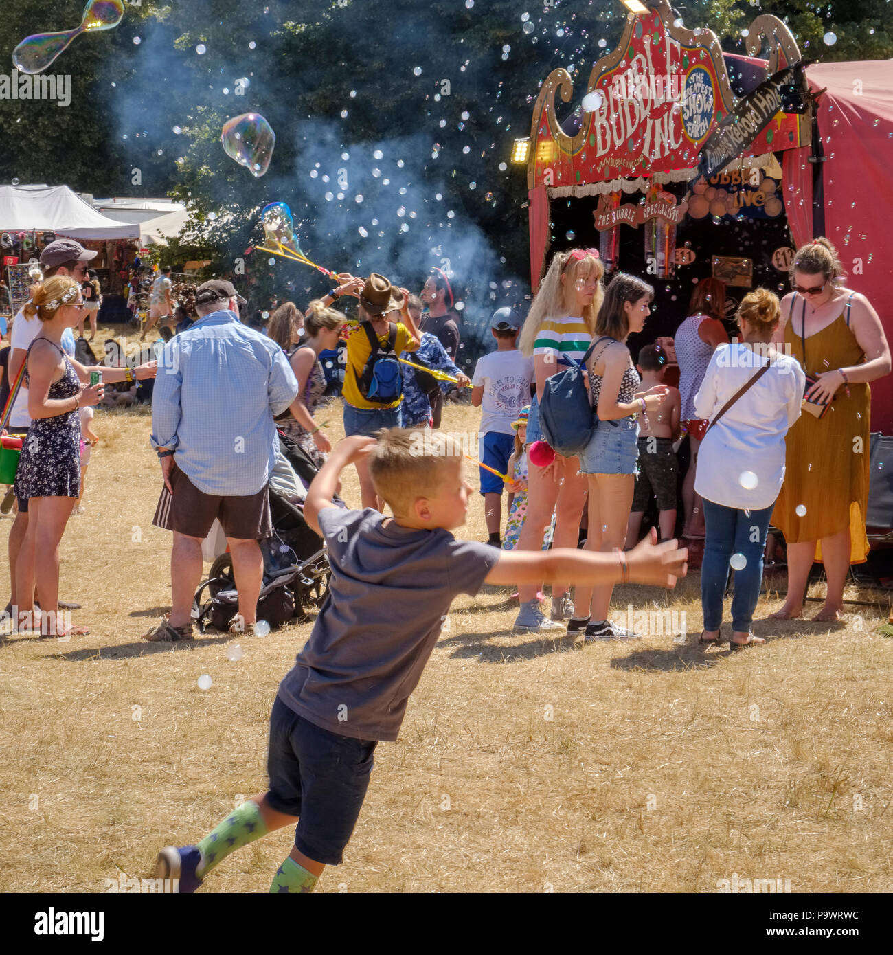 Junge jagen Blasen, Latitude Festival, Suffolk, Großbritannien. Stockfoto