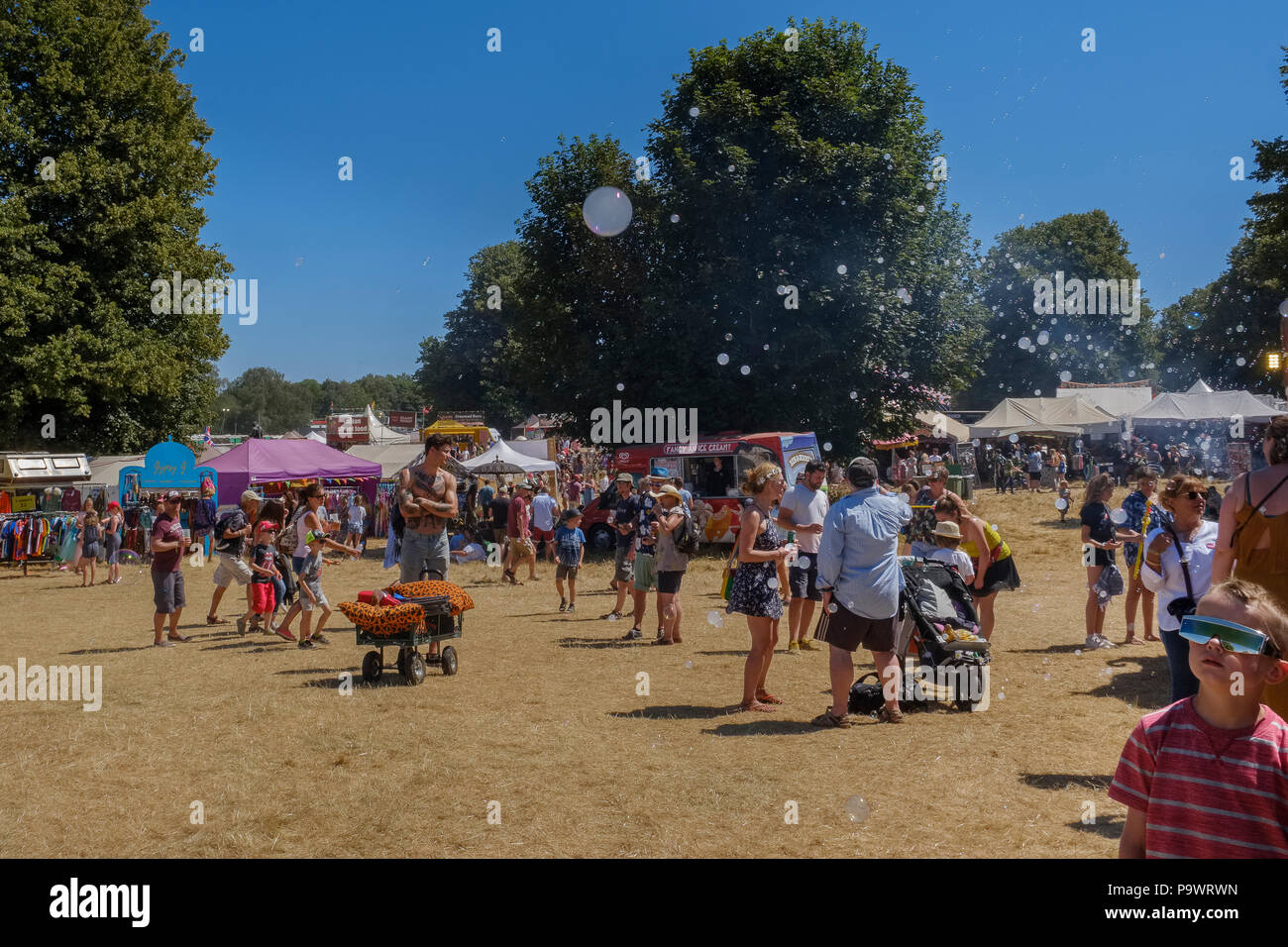 Boy blasen zusehen, wie geht das Leben um ihn herum, Latitude Festival, Suffolk, Großbritannien. Stockfoto