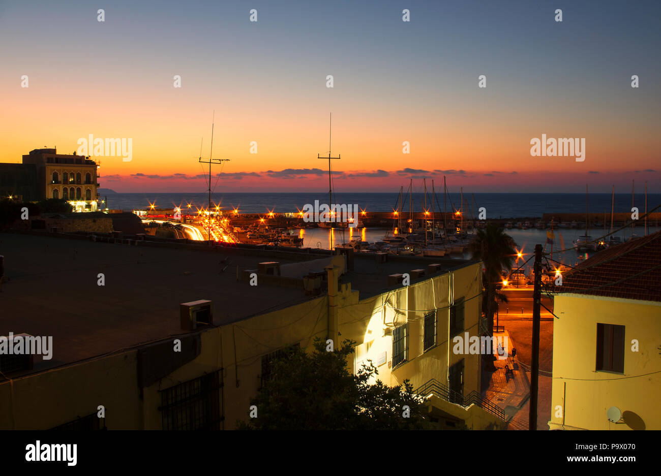 Nacht Landschaft am Hafen von Heraklion, mit strahlenden Lichtern und den Sonnenuntergang von der Sommersonne (Griechenland) Stockfoto