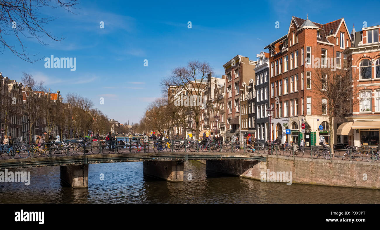 Viele Fahrräder auf einer Brücke mit Blick auf eine Gracht in Amsterdam, Niederlande, Europa Stockfoto