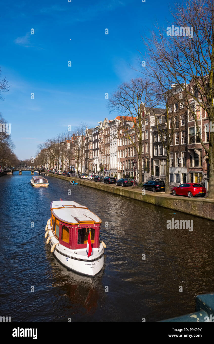 Grachtenfahrten in einem Boot mit Canal Häuser und touristische Ausflugsboote an einer Gracht in Amsterdam, Niederlande, Europa Stockfoto
