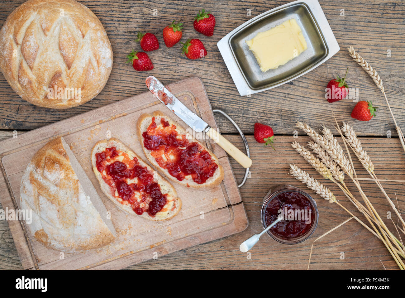 Erdbeermarmelade auf Brot mit Weizen und Erdbeeren auf einem Holz Hintergrund Stockfoto