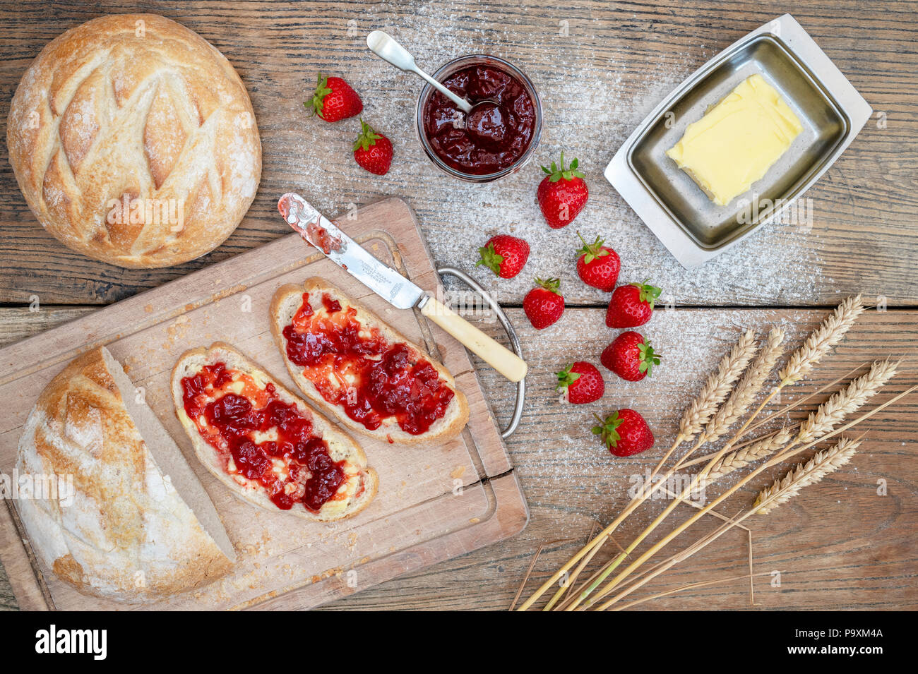 Erdbeermarmelade auf Brot mit Weizen und Erdbeeren auf einem Holz Hintergrund Stockfoto