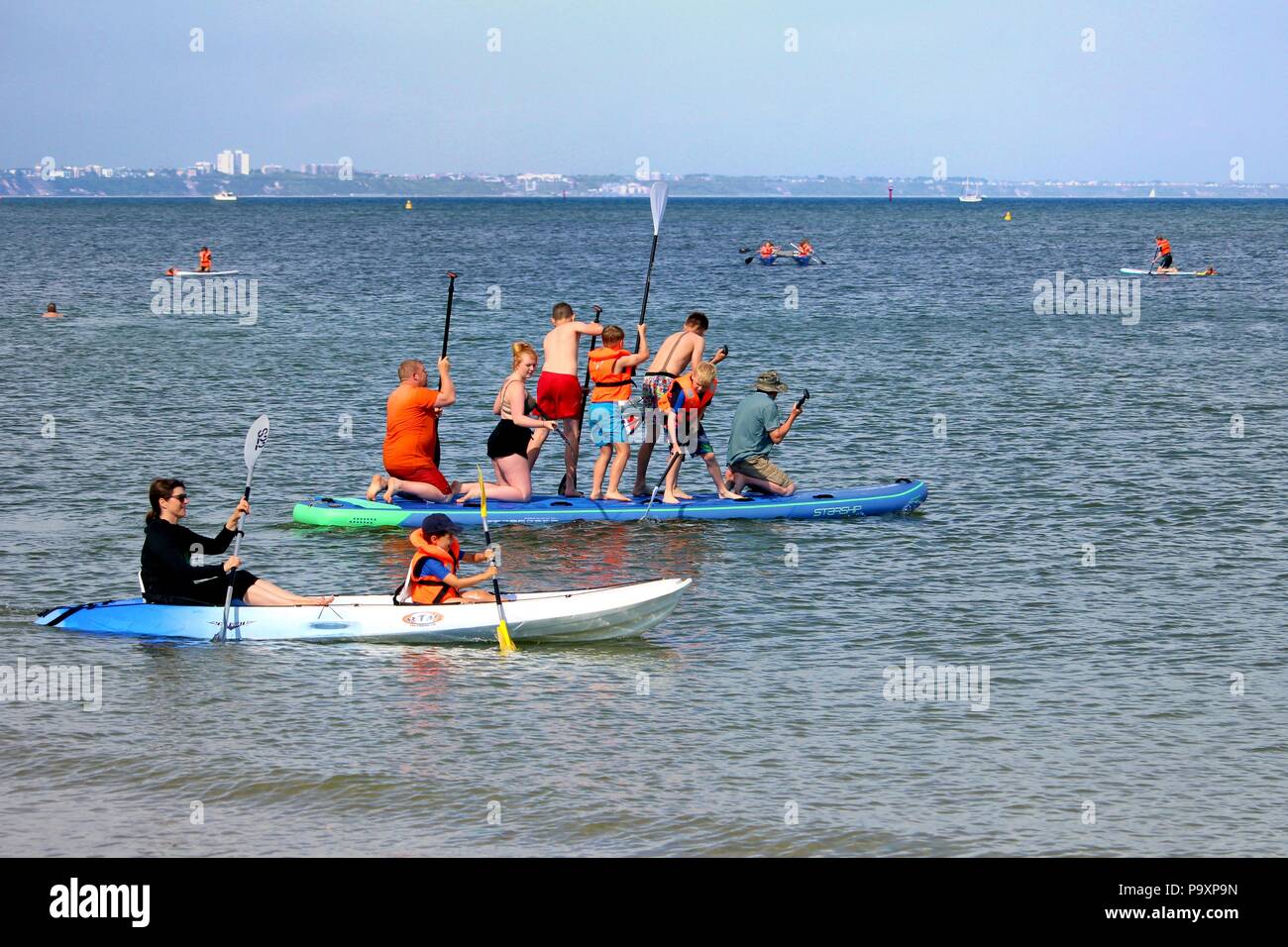 Studland, Dorset, England - 01. Juni 2018: Urlauber genießen Sie verschiedene Wassersportarten, Kanu, Kajak, paddleboarding, an einem schönen sonnigen Tag Stockfoto