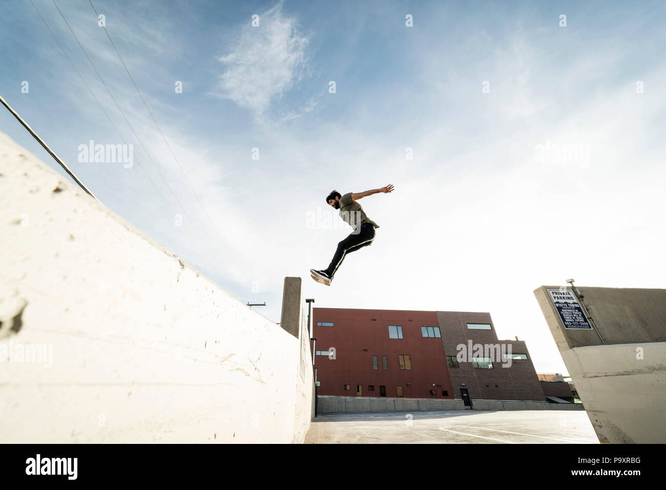 Seitenansicht des einzigen männlichen parkour Sportler von einer Wand zur anderen springen Stockfoto