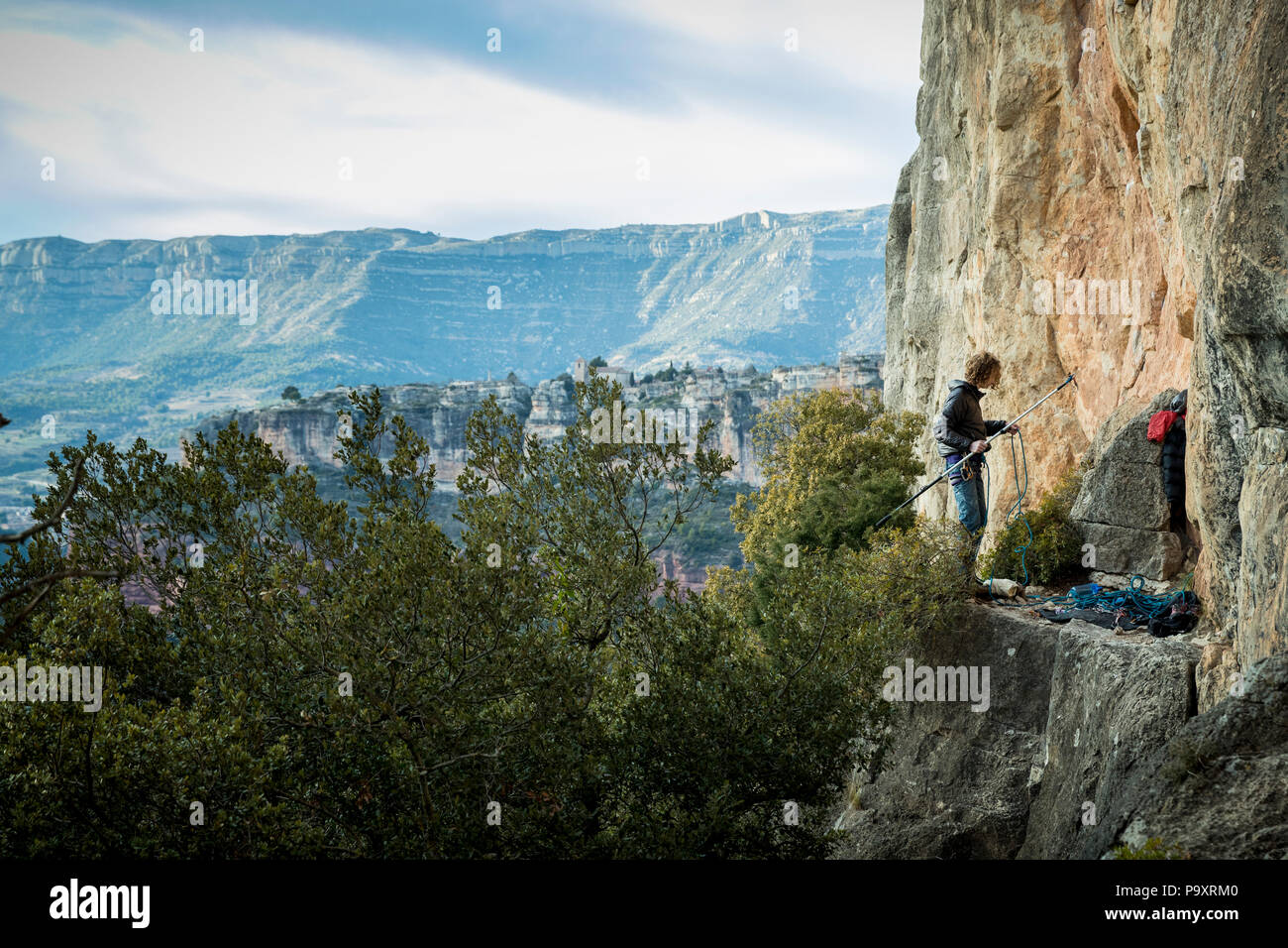 Fernsicht auf einem abenteuerlichen männlichen Kletterer Vorbereitung stick Clip an der Klippe, Siurana, Katalonien, Spanien Stockfoto