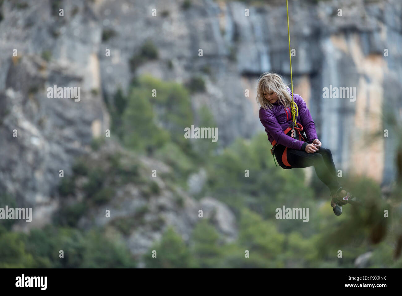 Abenteuerliche blonde junge Frau gesenkt von Klettern, Siurana, Katalonien, Spanien Stockfoto