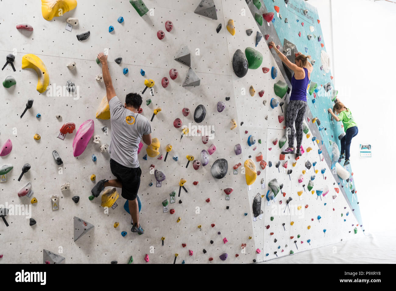 Mann, Frau und Mädchen klettern Kletterwand Stockfoto