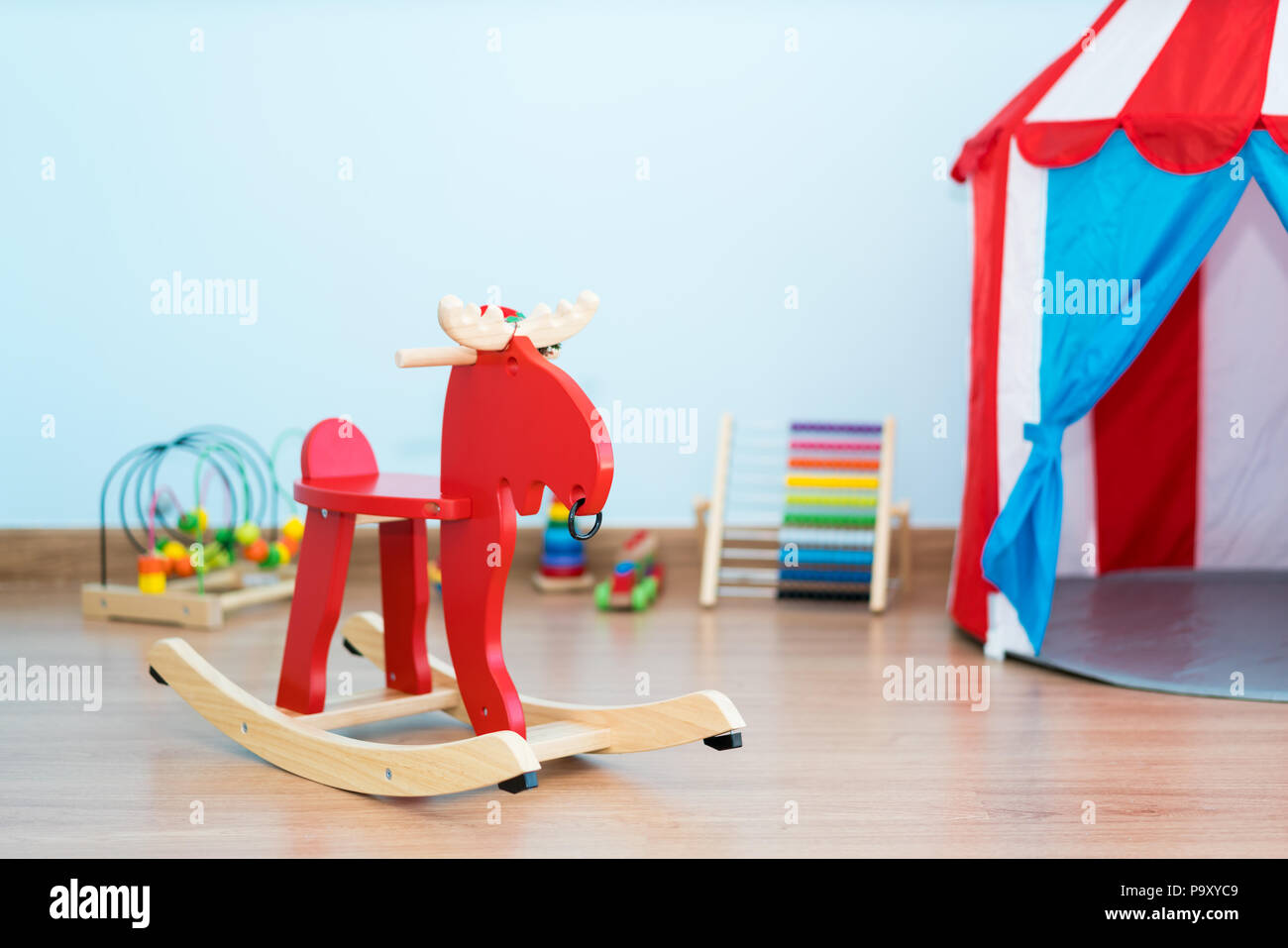 Red rockende Hirsche in der Nähe von Spielzeug, Baby Zimmer im Haus. Stockfoto