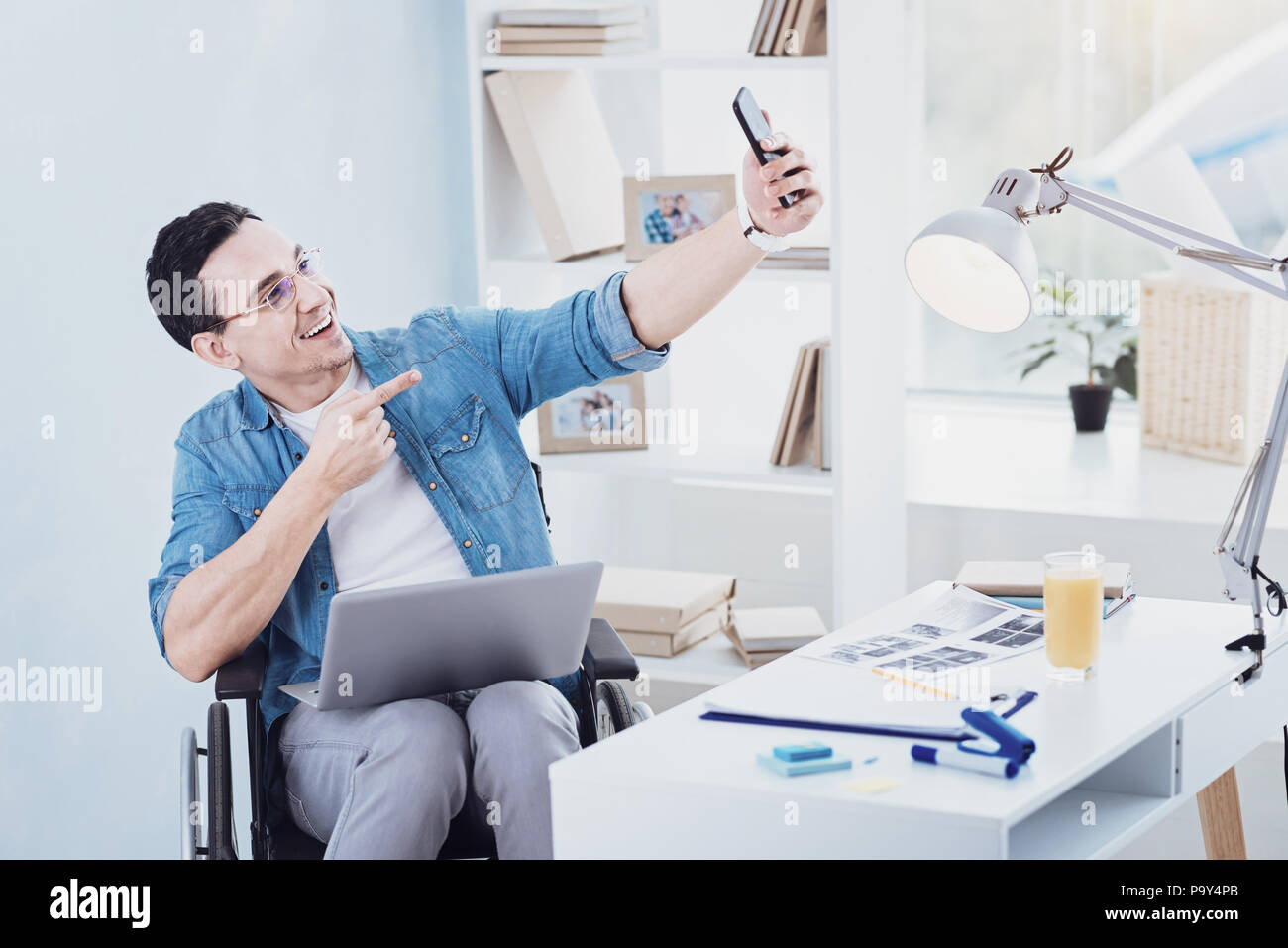 Fröhliche junge Mann an seinem Smartphone zeigen Stockfoto