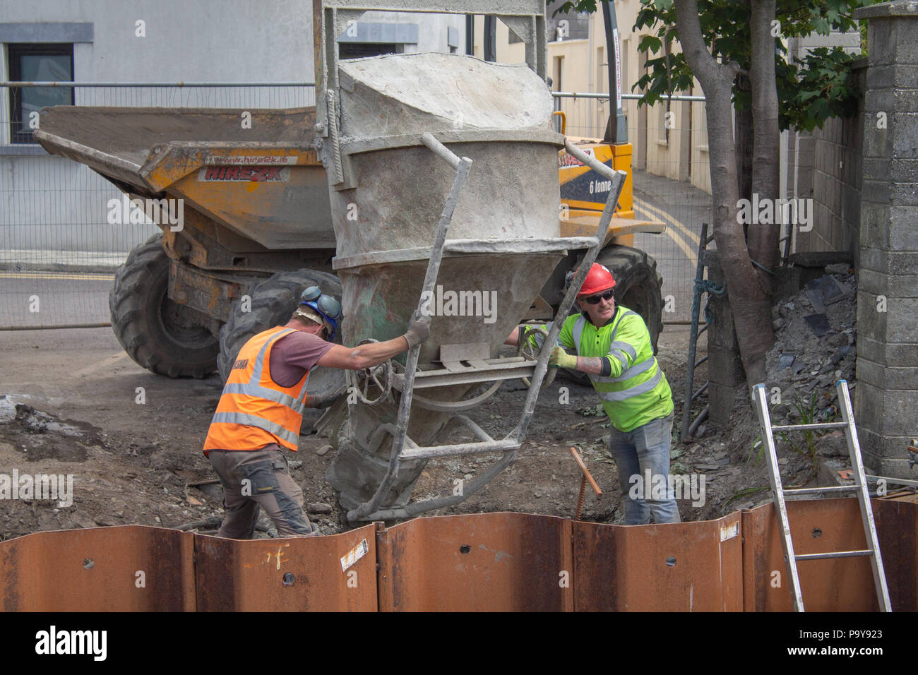 Erbauer Betonieren in Metall Schalung aus einem Trichter in dem Kran schwang. Stockfoto