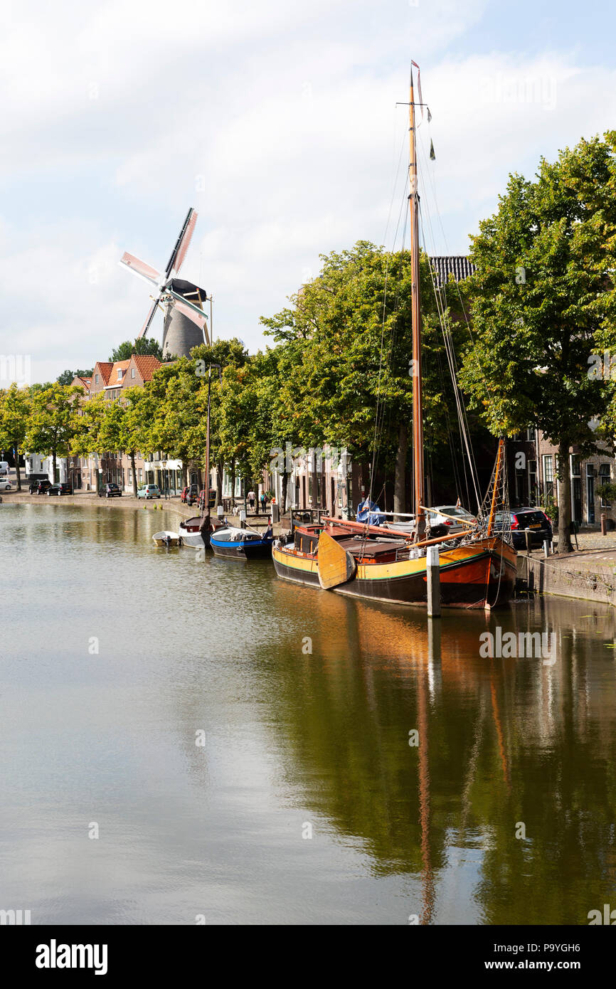 Ein Kanal und Boot in Schiedam, Niederlande. Schiedam hat höchsten traditionellen Windmühlen der Welt. Stockfoto